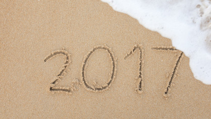 2017 text with white sandy beach and sea .