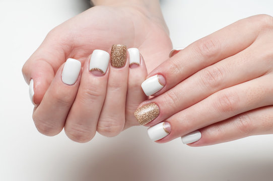 White, golden manicure on square long nails on a white background 
