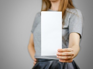 Woman showing blank white flyer paper. Leaflet presentation. Pamphlet hold hands. Girl show clear...