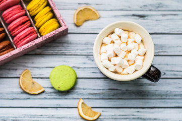 Still life with cup of tea and sweets on the wooden background