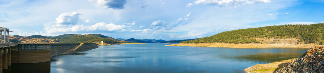 Beautiful panorama landscape of lake and dam surrounded by hills and mountains