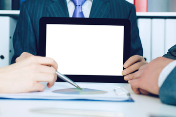 Business man showing digital tablet to coworkers in office.