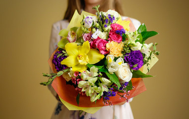 Beautiful girl in dress holding a bouquet of different flowers. Isolated