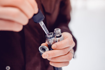 vaping man holding a mod device. cloud of vapor. Vape