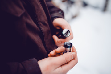 vaping man holding a mod device. cloud of vapor. Vape