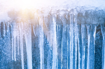 Icicles hanging against a background of wall