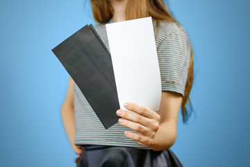 Woman showing two blank white and black flyer paper. Leaflet presentation. Pamphlet hold hands....