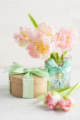 Obraz na płótnie Canvas Pink tulips and gift box with green ribbon