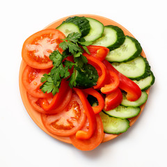 tomato, bell pepper and cucumber slices on plate on white background