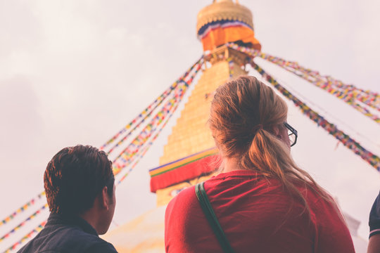 European traveler with her guide at boudhanath stupa on faded vintage tone