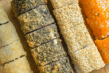 Top view of sushi rolls set served on wooden dish, copy space