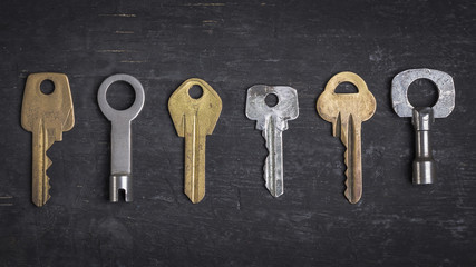 Old keys on a dark wooden background.