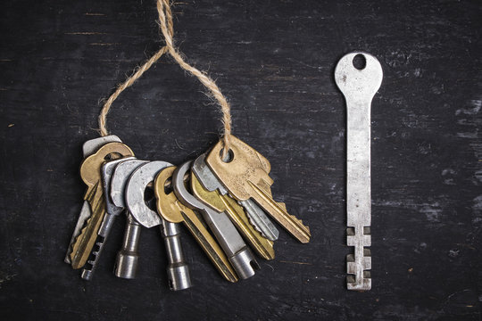 Old keys on a dark wooden background.