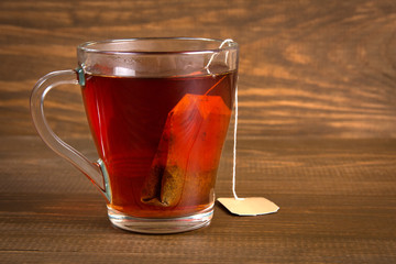 Glass cup of black tea on a dark wooden background