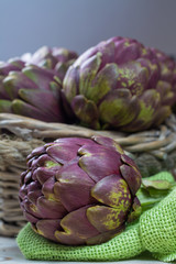 Fresh big Romanesco artichokes green-purple flower heads ready to cook