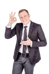 businessman showing OK while standing against white background