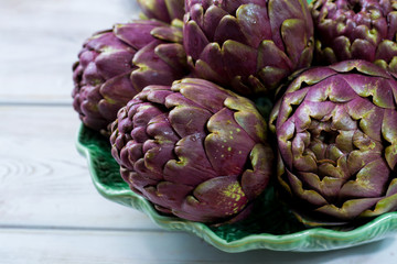Fresh big Romanesco artichokes green-purple flower heads ready to cook