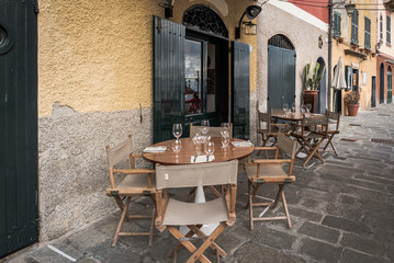 Wooden table near traditional Italian cafe in Portofino town, Italy