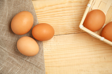 Brown Eggs in basket with homespun fabric close up