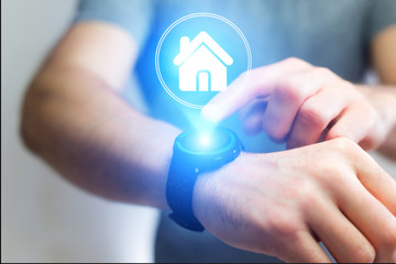 Businessman hand holding smartwatche with home icon