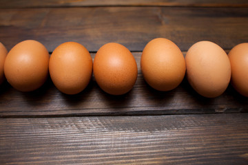 Closed, fresh chicken eggs on a natural wooden background
