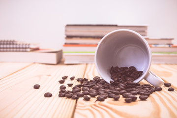 Roasted coffee beans and mug on wood table
