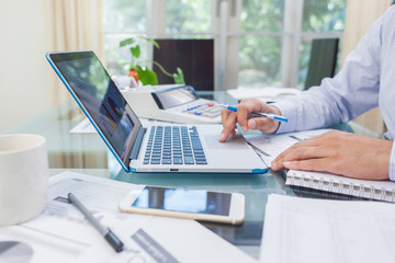 Business man working on open laptop at home office