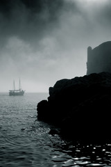 Old sailing boat passes the castle walls of Dubrovnik's old town, location of  TV show Game of...