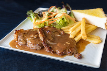 Grilled steaks, boiled French fries and vegetable salad