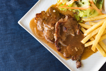 Grilled steaks, boiled French fries and vegetable salad