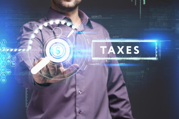 Business, Technology, Internet and network concept. Young businessman working on a virtual screen of the future and sees the inscription: Taxes