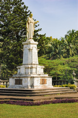 Fototapeta na wymiar Statue of Jesus near Catedral de Santa Catarina, known as SE Cathedral surrounded by palm trees in Old Goa, India
