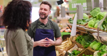 Shop assistant in grocery store helping shopper - Powered by Adobe