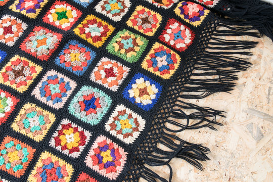 Woolen colorful blanket made from granny squares - diagonal flat lay