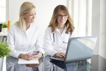 Making an appointment. Shot of a female doctor working together with her assistant in exam room and...