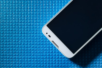 White smartphone on a blue background. Black screen