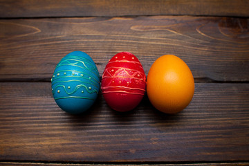 Closed, colored in different bright colors chicken eggs for the holiday Easter on natural wooden background