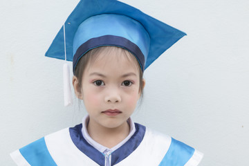 Cute asian kids with graduation robe. Educational concept. Copy space.