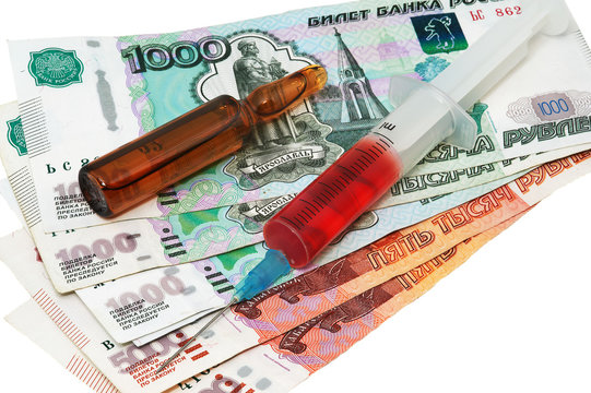 Syringe with the needle with medicine, ampule and rubles on white background