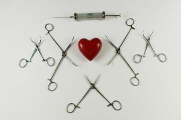 Medical surgical Instruments and heart on white background.