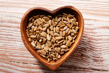 Sunflower seeds in wooden heart shape bowl