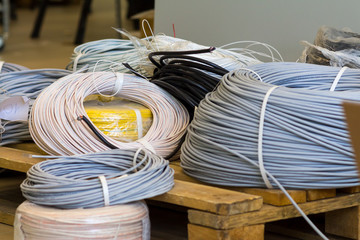 rolls of cable various colors and diameter on a wooden pallet