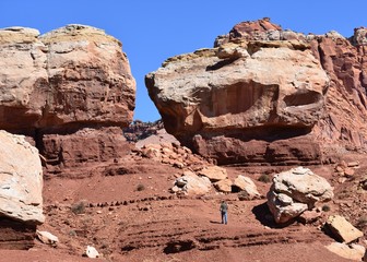Fototapeta na wymiar Man hiking near Twin Rocks in Capitol Reef, Utah. 