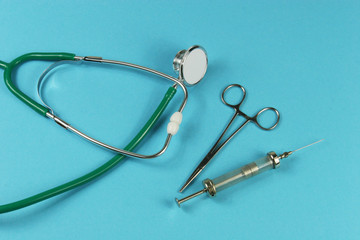 Stethoscope and syringe on blue background.