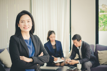 Asian business woman standing front of her teams in office.