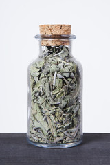 Dried sage herb inside a glass jar. Herbs and plants for tea.