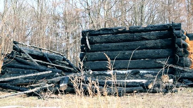 Burnt wooden house after a fire, daytime panning