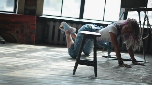 irl artist with makeup dancing on the floor. Stylish art workshop.