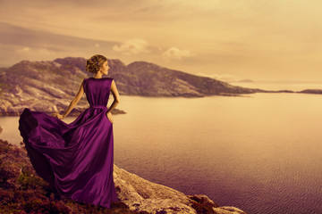 Woman in Elegant Dress on Mountain Coast, Fashion Model in Flowing Gown Cloth, Looking to Landscape...