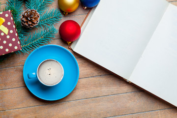 cup of coffee, opened notebook and christmas decorations on the wondeeful brown wooden background